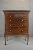 A George III or later mahogany chest on stand with a dentil cornice over a fluted and roundel frieze