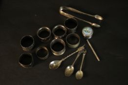 A collection of silver, including a pair of sugar tongs, various napkin rings and a silver and