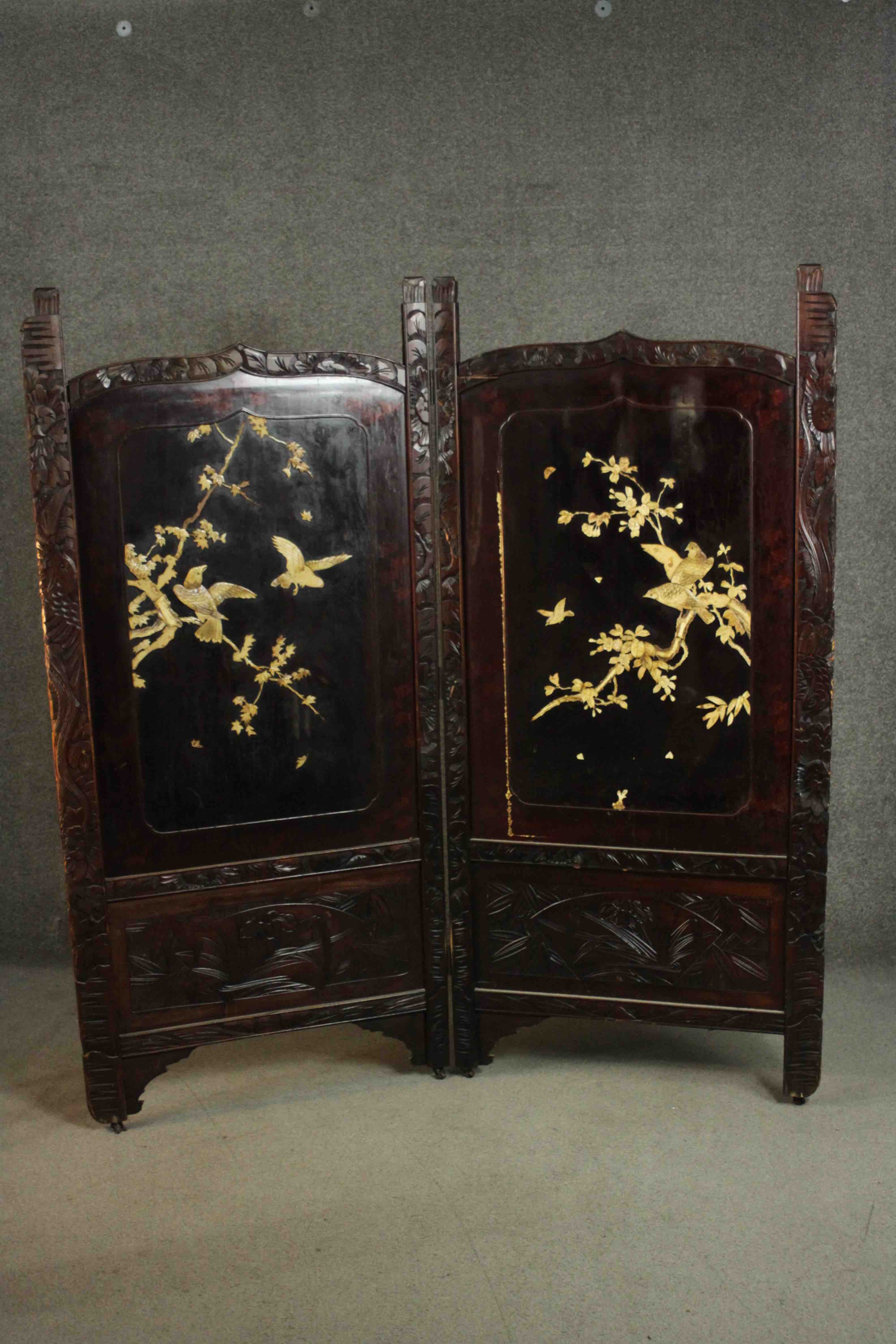 A late 19th or early 20th century Japanese two fold lacquered screen with carved bone inlaid