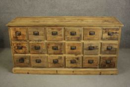 A contemporary rustic pine long chest, the rectangular top with a moulded edge over three tiers of