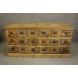 A contemporary rustic pine long chest, the rectangular top with a moulded edge over three tiers of