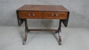 A George III style flame mahogany sofa table, the crossbanded top with drop leaves, over two short