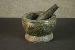 A carved granite mortar and pestle. H.13 Dia.20cm.