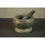 A carved granite mortar and pestle. H.13 Dia.20cm.