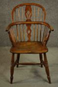 A 19th century elm stick back Windsor armchair with pierced back splat on stretchered tapering