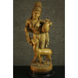 An Indian 20th century carved White Cedar figure of a woman with a deer holding a water vessel. H.62