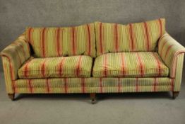 A large contemporary sofa, upholstered in striped fabric with tapering block feet terminating in