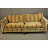 A large contemporary sofa, upholstered in striped fabric with tapering block feet terminating in