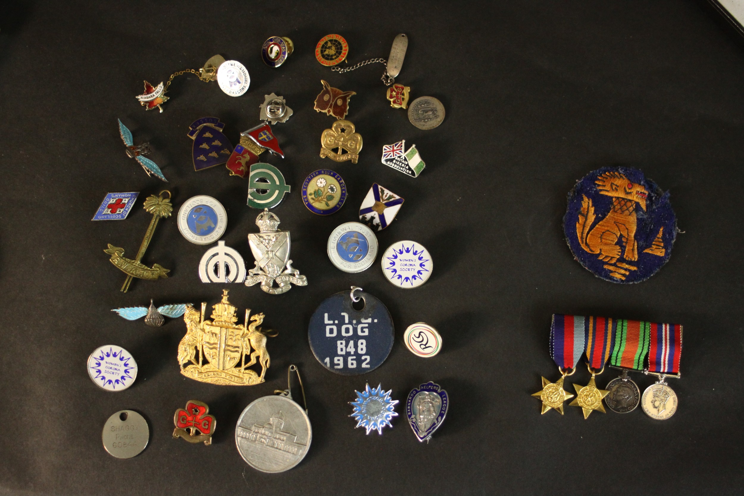 A large collection of various militaria medals and badges, including two silver and enamel