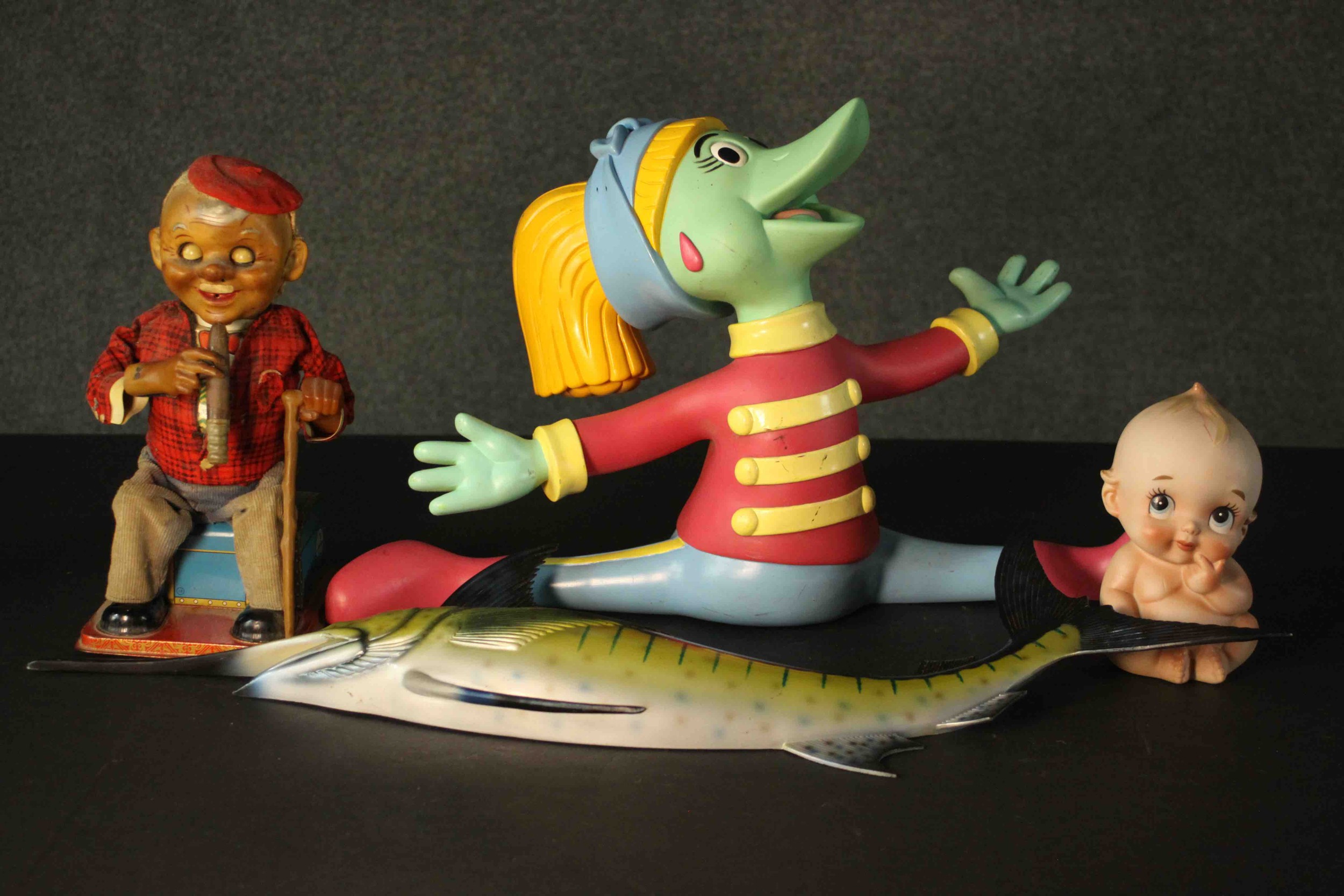 Three vintage toy characters and a fibreglass wall mounted swordfish. The wind up tin plate toy an