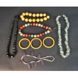 A collection of costume jewellery including three Bakelite bangles, a large striped Bakelite bead