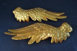 A large pair of gold painted resin angel wings. L.58cm