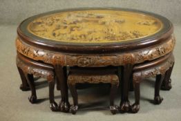 A 20th century Indonesian hardwood coffee table, the oval top ornately carved with a variety of