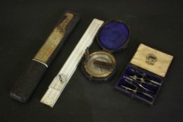 A leather cased 19th century compass along with a boxed slide rule and leather cased set of