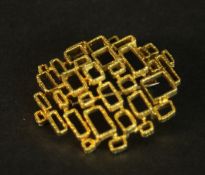 An 18 carat yellow gold mid-century brutalist design openwork brooch. Stamped 750 with S with a line