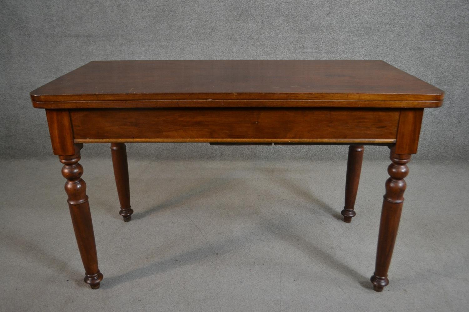 A Victorian walnut tea table of rectangular form with a fold over top on turned legs. H.70 W.116 D.