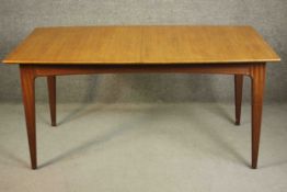 A circa 1960s teak extending dining table, of rectangular form with an additional leaf, on