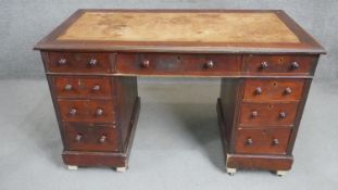 A Victorian mahogany pedestal desk with an arrangement of nine drawers with knob handles on plinth