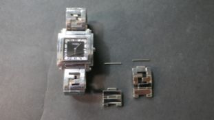 A ladies stainless steel square faced designer Fendi watch with black dial and roman numerals. Spare