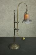 An Edwardian style brass desk lamp with polychrome glass shade on an adjustable mount and a circular