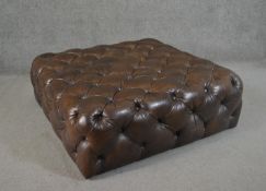A contemporary brown deep buttoned leather hearth stool. H.33 W.100 D.100cm