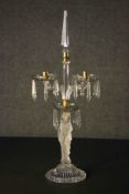 A vintage cut glass twin branch table candelabra the sconces hung with lustre drops supported by