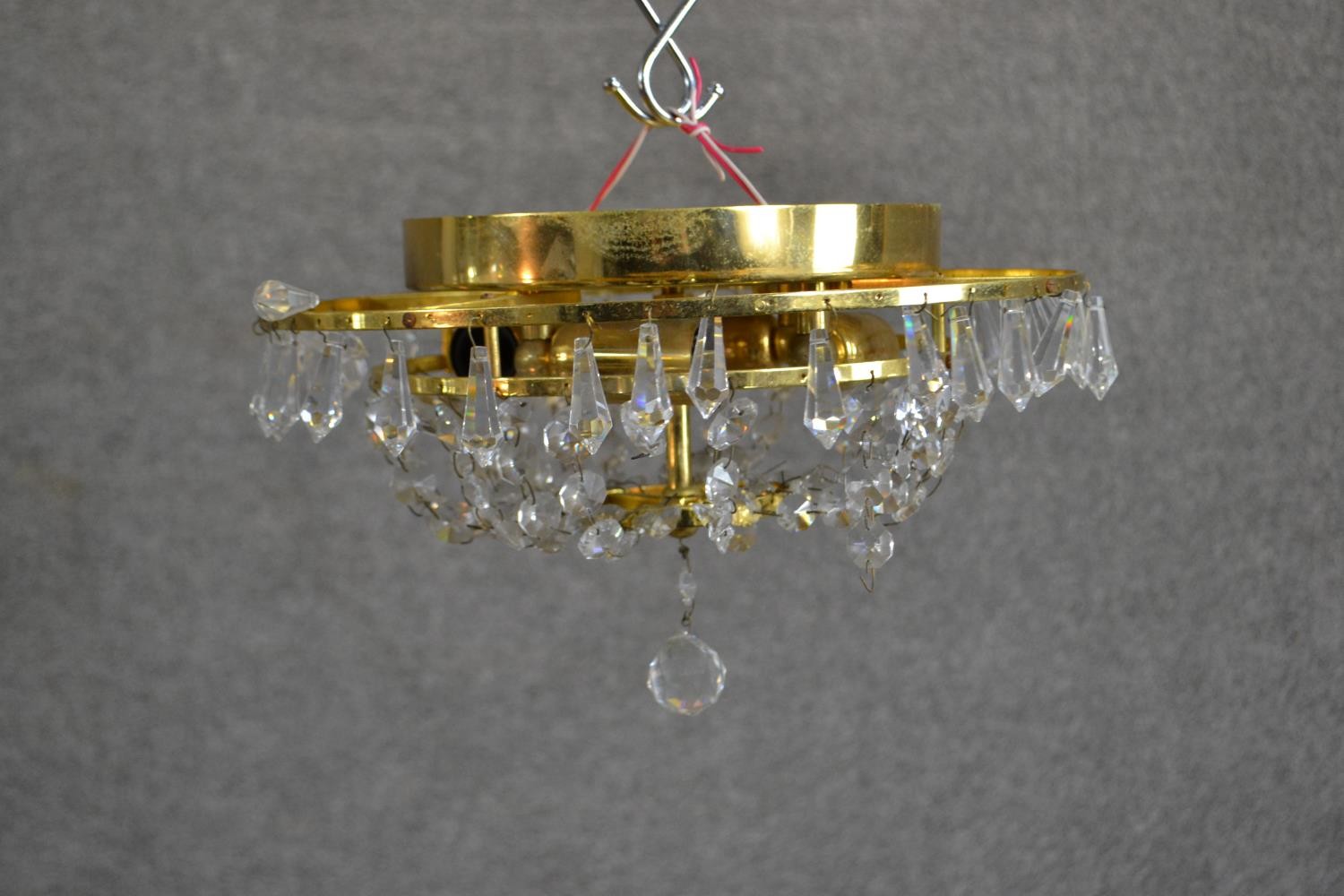 A contemporary circular tiered brass ceiling light, hung with faceted glass lustres. Diam.32cm