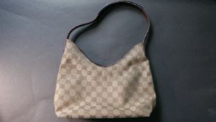 A Gucci brown leather and monogrammed canvas ladies hand bag with metal casing to the handle with