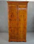 A reproduction Sheraton style wardrobe, with a marquetry inlaid frieze to the cornice over two