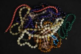 A collection of eleven gemstone and glass bead necklaces, including a Baltic amber bead necklace (