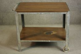 An industrial drinks serving trolley with two tiers of oak planks on a metal frame and castors to