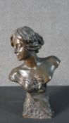 An Art Nouveau spelter bust of a lady in a dress on a textured base, indistinctly signed. H.29 W.