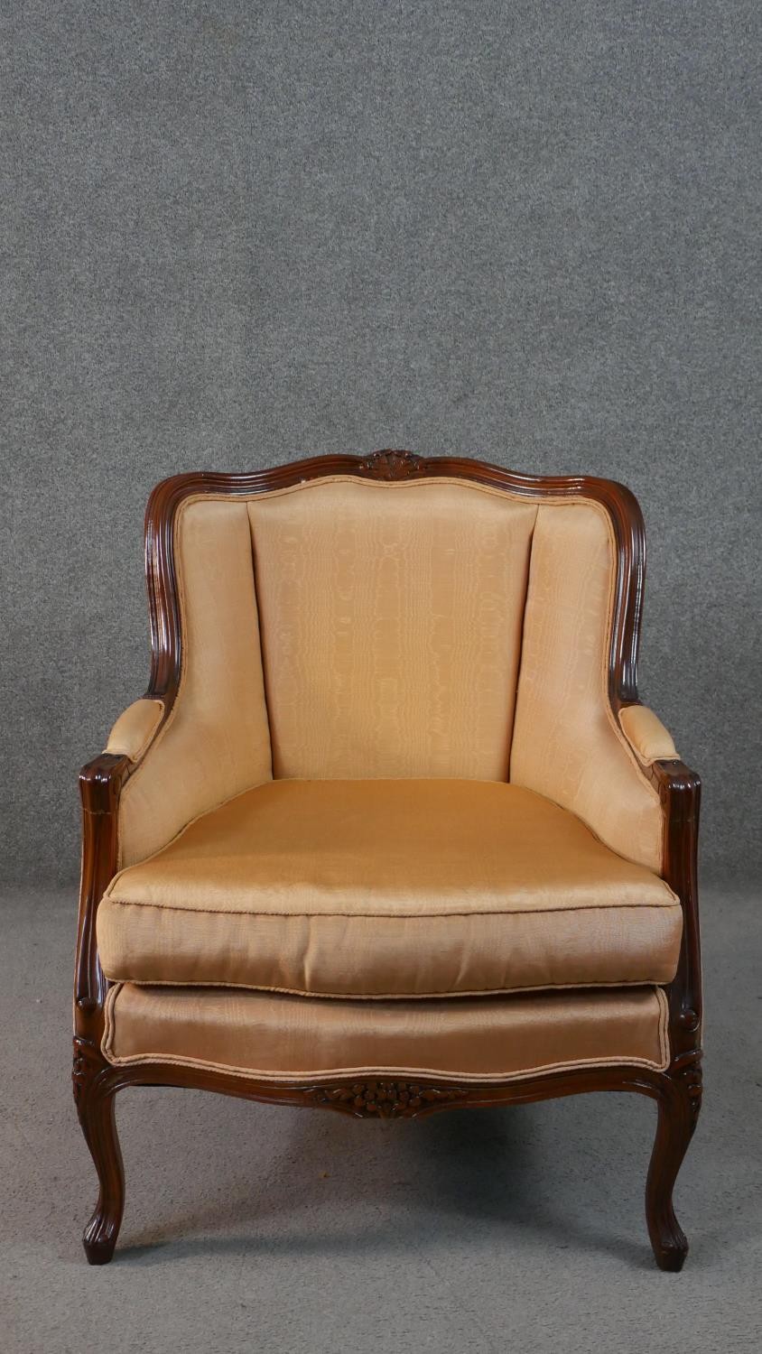 A late 20th century French show wood armchair, with a carved frame, upholstered in salmon colured