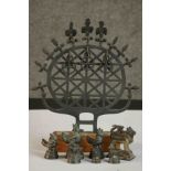 A cast iron replica of a Hittite sun disk replica on a wooden base along with a set of graduated