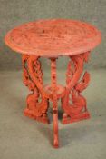 A Chinese or Indonesian cinnabar lacquered style circular occasional table, ornately carved allover,