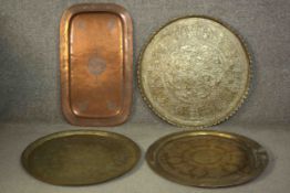 A collection of four 19th century Oriental brass and copper trays. Three circular trays