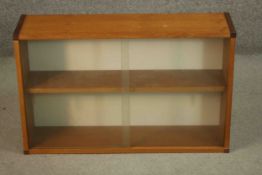 A vintage teak wall hanging cupboard with glass sliding doors. H.51 W.81 D.22cm.