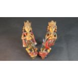 A pair of carved and painted Indian deities. H.31 W.27cm