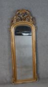 A large early 20th century carved giltwood arched wall mirror. The top with a pierced grape, bird