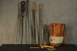 A collection of carved African sticks along with a leather and woven shoulder bag etc. L.94cm. (