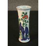 A 19th century Chinese Wucai porcelain cylindrical vase decorated with flowers behind rocks. (