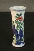 A 19th century Chinese Wucai porcelain cylindrical vase decorated with flowers behind rocks. (