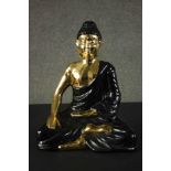 A large ceramic black and gold Buddha figure. H.45 W.35 D.21cm.