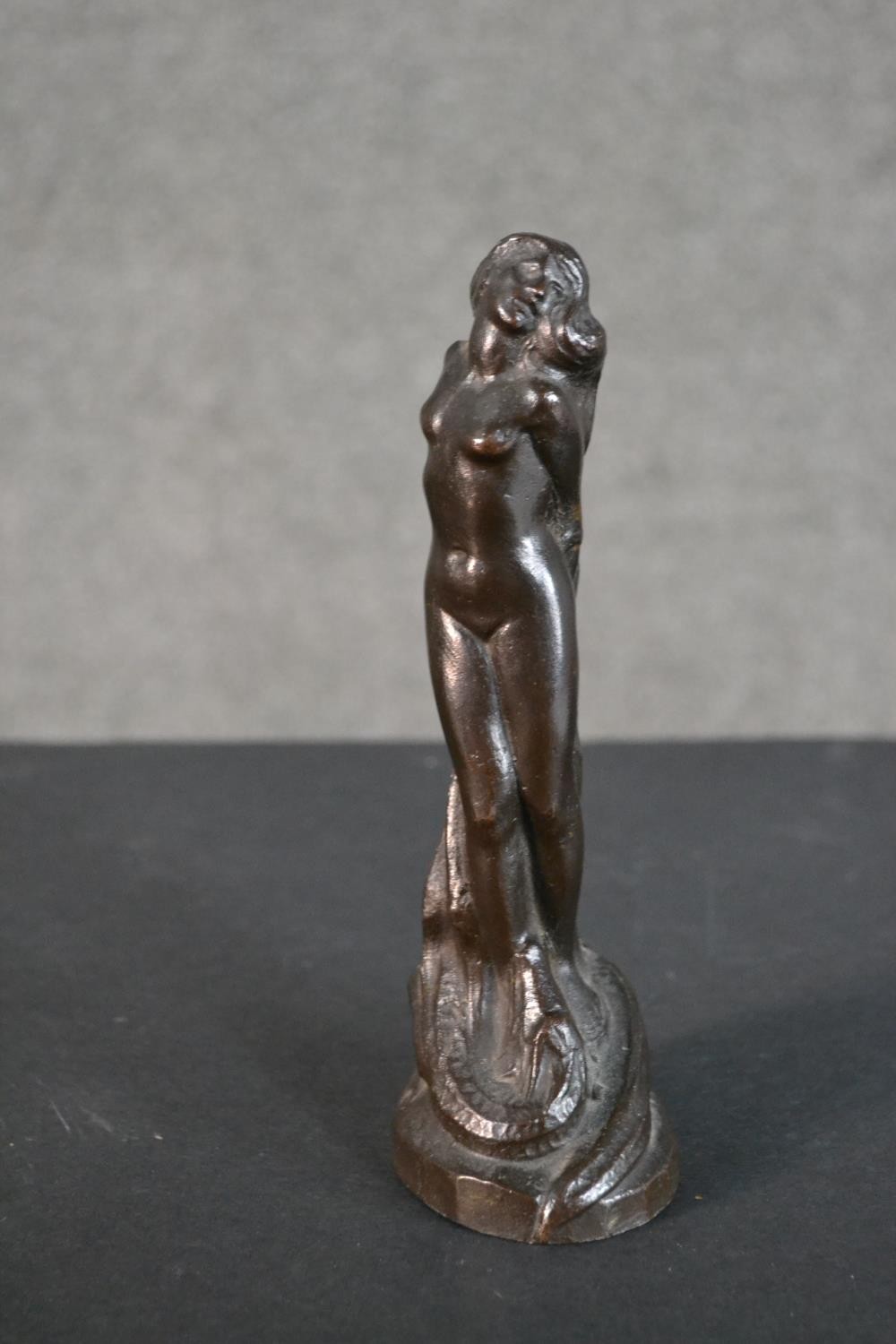 A 20th century bronze figurine of a nude woman tied at a stake with dragon at her feet. Dated