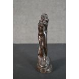 A 20th century bronze figurine of a nude woman tied at a stake with dragon at her feet. Dated