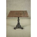 A black painted Victorian cast iron pub table with a later square slatted teak top. 1 H.71 W.80 D.