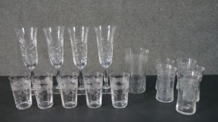 A collection of etched drinking glasses, including a set of four hand cut floral design champagne