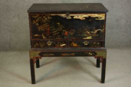 An early 19th century chest on stand with all over hand decorated black lacquered Chinoiserie