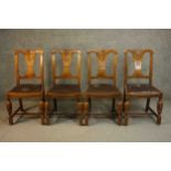 A set of four circa 1940s oak dining chairs, with a carved splat back over a brown faux leather drop