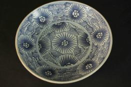 A Chinese Swatow ware hand painted blue and white footed bowl with stylised floral design. Dia.27cm.